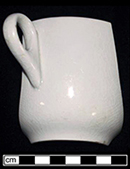 White granite handled cup. Burned in 1915 fire that destroyed farmstead. Vessel height: 2.88”, Vessel rim diameter:3.50”, Vessel V-136 - from 18MO609.